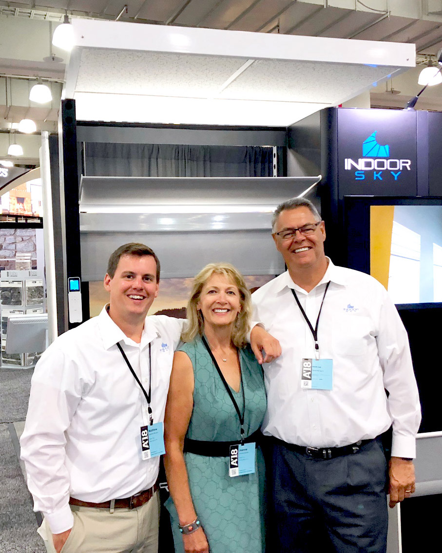 The Indoor Sky team standing in front of the tradeshow display.